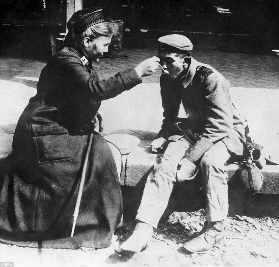 O asistenta de la Crucea Rosie din Franta hraneste un soldat ranit: Imagini emotionante din timpul Primului Razboi Mondial