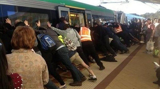 Clipul zilei: Zeci de pasageri au impins vagonul unui tren pentru a ajuta un barbat care cazuse! VIDEO