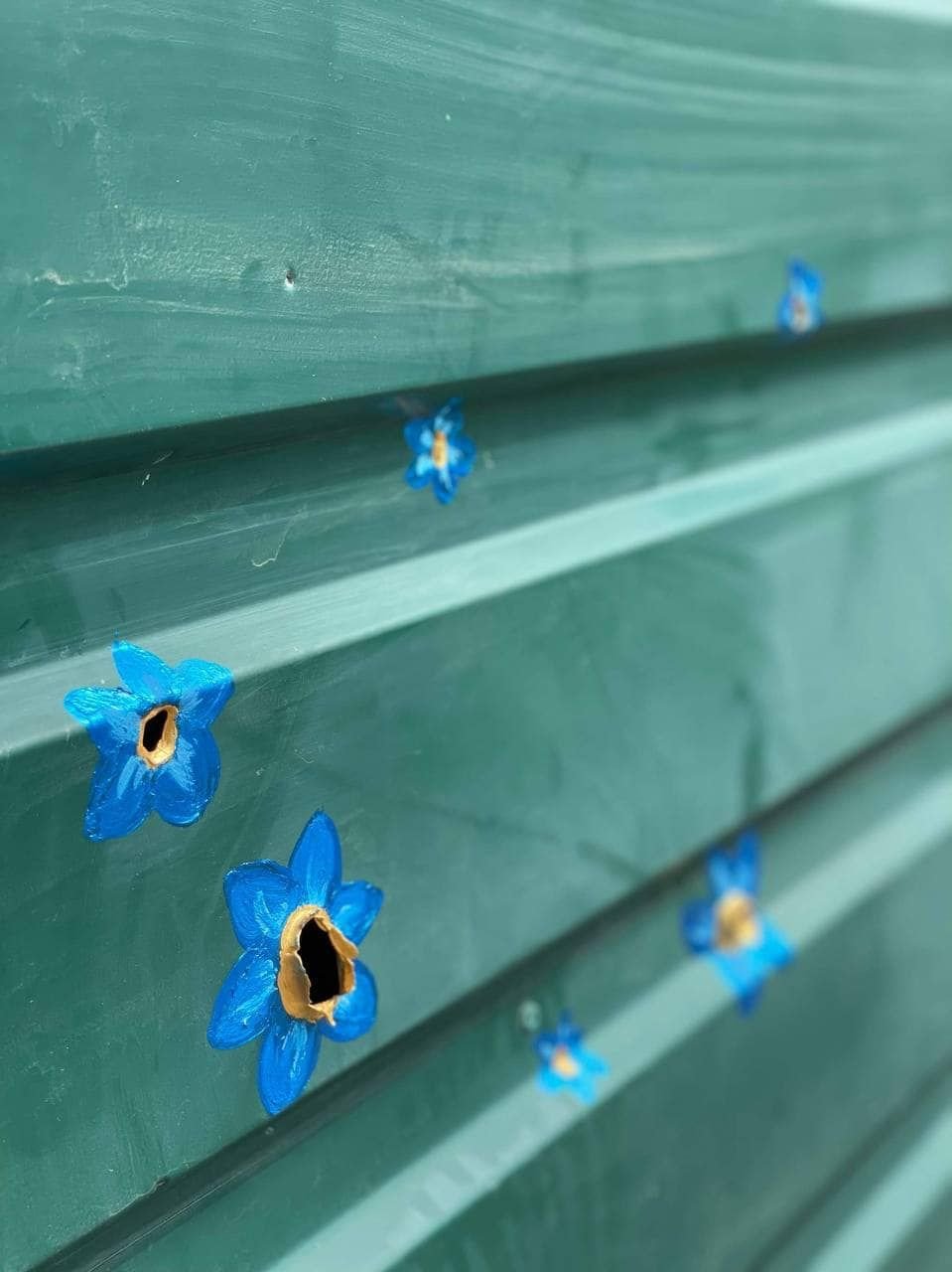 Ucraina înflorește! Un artist a venit din Canada pentru a picta flori pe găurile lăsate de gloanțe în Bucea - FOTO